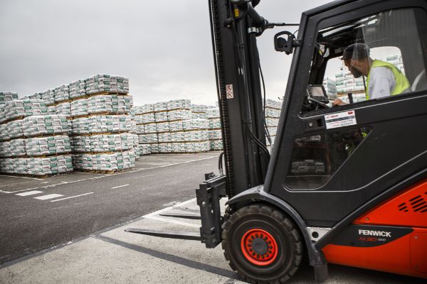 Un chariot de manutention automoteur à conducteur porté lors d’une opération de stockage des palettes de sacs.