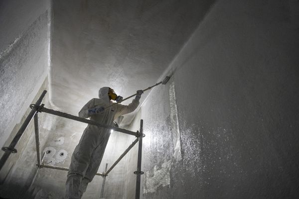  Un opérateur effectue une application de revêtement alimentaire à l'intérieur d'une cuve