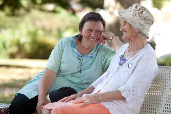 Auxiliaire de vie accompagnant une personne âgée pour une sortie à l’extérieur