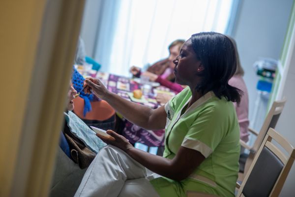 Aide au repas par une aide-soignante avec une tenue dédiée dans un EHPAD