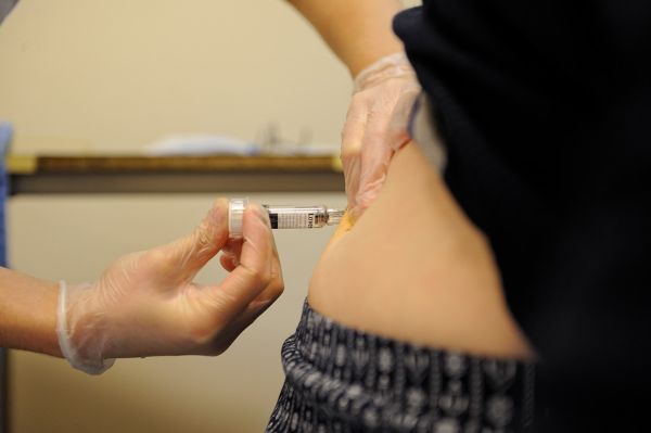 Infirmière effectuant une injection sous cutanée chez un patient à domicile