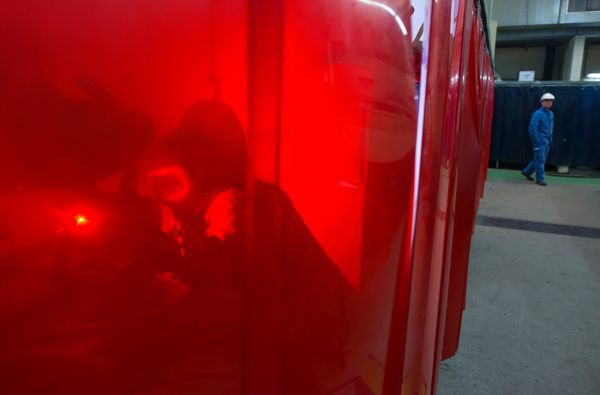 Soudeur derrière un rideau opaque de protection 