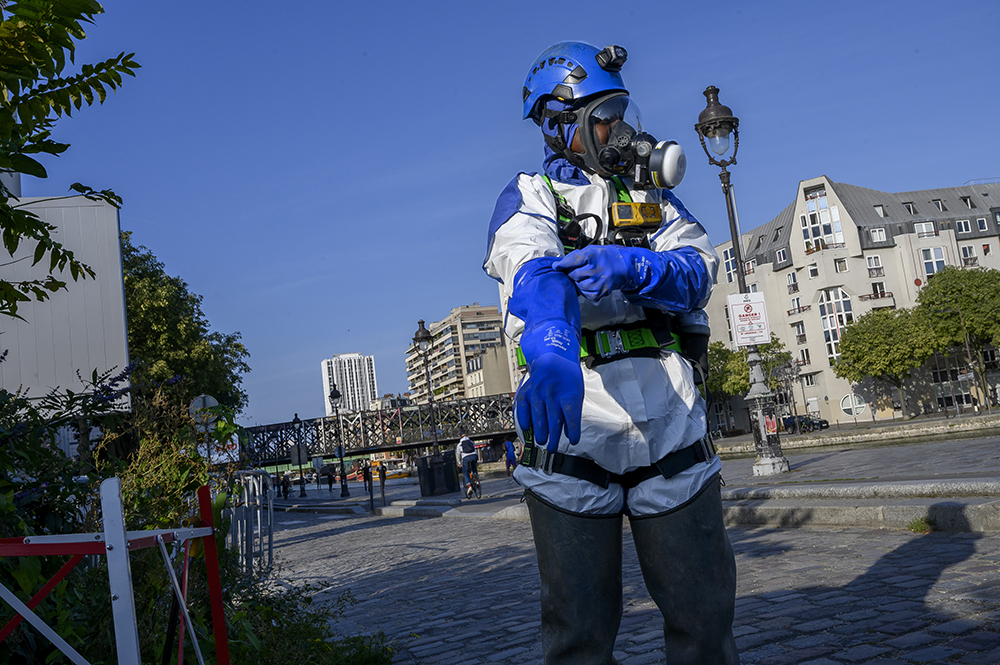 Opérateur se préparant à intervenir dans un réseau d’assainissement : il porte notamment un contrôleur d'atmosphère multigaz, un masque autosauveteur et un harnais de sécurité