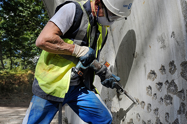 Travailleur utilisant un piqueur sur un chantier de BTP
